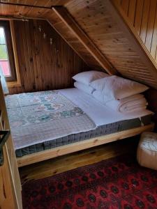 a bed in a wooden room with a attic at Domek wypoczynkowy Gowidlino in Gowidlino