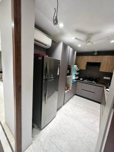 uma cozinha com um frigorífico de aço inoxidável e armários em The LUTF em Nova Deli