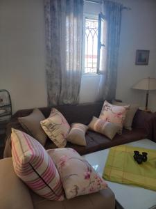 a living room with a couch with pillows and a window at Appartement Cerine 1 , nur 100 Meter bis Tantana Strand in Port El Kantaoui