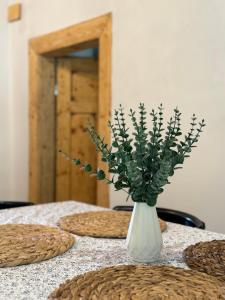 biała waza z kwiatami na stole w obiekcie Banícka kuťka na Železníku w mieście Revúca