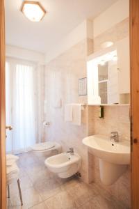 een badkamer met 2 wastafels en 2 toiletten bij Residence Al Caminetto in Molveno