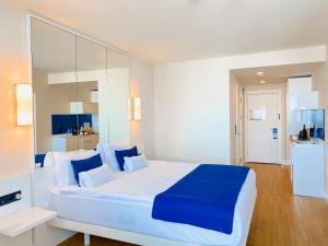 Batumi High View في باتومي: غرفة نوم بسرير كبير ومخدات زرقاء وبيضاء
