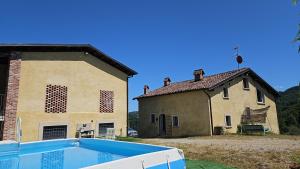a house with a swimming pool in front of it at casa nel verde Cà dla cola in Mombasiglio