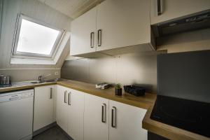 una pequeña cocina con armarios blancos y una ventana en Le Saint-Martin - Hypercentre - Netflix, en Tours