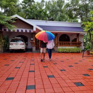 a man and woman walking down the street with an umbrella at Serenity Villa and Treehouse in Palakkad