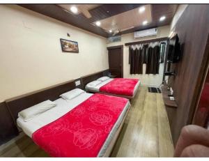 um quarto com duas camas e uma tv nele em Hotel Radhika Palace, Mount Abu, Rajasthan em Monte Abu
