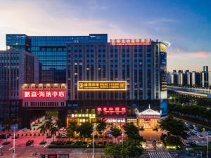 a large building with neon signs in a city at Vienna Hotel Shenzhen Guangming Guangqiao Road Tianliao in Shenzhen