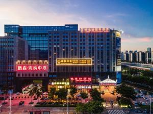 深圳维也纳酒店深圳光明光侨路田寮店的城市里挂满霓虹灯的大楼