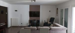 sala de estar con sofá y TV de pantalla plana en La Villa Farniente, en Bandol