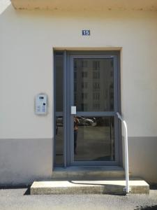 a door to a building with a person standing outside at Terrasse, vue sur jardin arboré et place de parking in Rennes