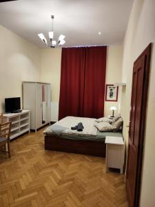 a bedroom with a bed and a red curtain at Stella apartments in Prague
