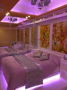 1 dormitorio con 3 camas con iluminación púrpura en H-SEVEN TOYAMA (Adult Only), en Takaoka