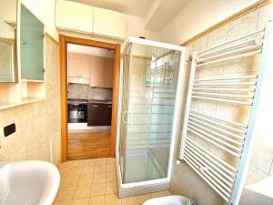 y baño con ducha acristalada y lavamanos. en Graziosa in coorte tranquilla con parcheggio gratuito riservato, en Cologno Monzese