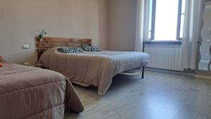 1 dormitorio con 2 camas junto a una ventana en Affittacamere Happy, en Porto SantʼElpidio