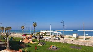 a park with a playground next to the beach at Affittacamere Happy in Porto SantʼElpidio