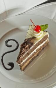 ein Stück Schokoladenkuchen mit einer Kirsche auf einem Teller in der Unterkunft Clanwilliam Hotel in Clanwilliam
