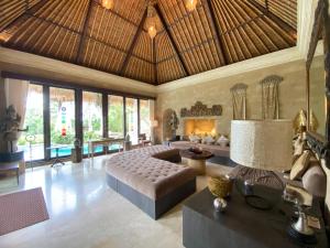 a bedroom with a bed and a couch in a room at Akasha New Earth Haven Villa in Ubud