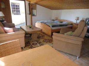 a living room with a bed and chairs and a table at Idyllic studio apartment near Kaifenheim and near the forest in Kaifenheim