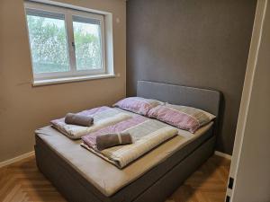 ein Bett mit vier Kissen und einem Fenster in der Unterkunft GardenLoft no1 in Wien