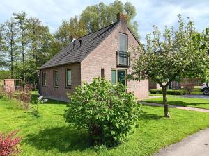 una pequeña casa de ladrillo con balcón en un patio en Ellen's home en Ewijk