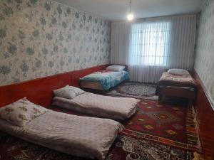 a room with three beds and a rug at Xinaliq BedBreakfast in Quba