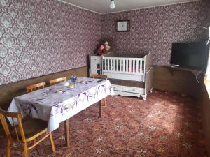 a dining room with a table and a baby crib at Xinaliq BedBreakfast in Quba