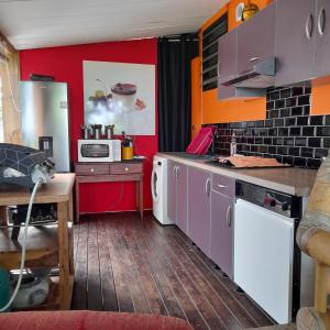 a kitchen with red walls and purple cabinets at Freedomhome974 in Le Tampon