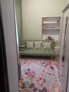 a living room with a green couch and a rug at Чавандоz in Yakkasaray