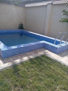 una piscina en un patio trasero con una baldosa azul en Чавандоz en Yakkasaray