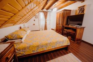 a bedroom with a bed and a flat screen tv at Cabana Paradisul Verde Neamt in Târgu Neamț