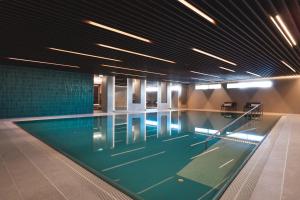 a large swimming pool in a building at Enter St Elisabeth Suites & Spa in Tromsø