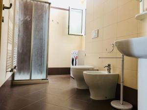 een badkamer met 2 toiletten, een wastafel en een douche bij Residenza zeus 6 in Gallipoli