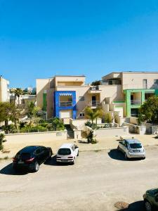 drie auto's geparkeerd op een parkeerplaats voor een gebouw bij Residenza zeus 6 in Gallipoli