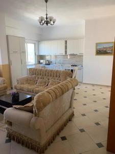 een woonkamer met 2 banken en een keuken bij Ema Apartament in Durrës