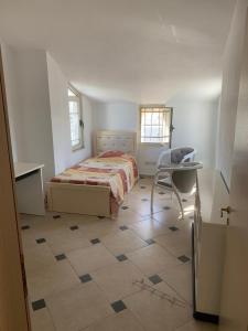 een slaapkamer met een bed, een bureau en een stoel bij Ema Apartament in Durrës