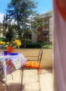 una mesa y una silla con un jarrón de flores en el balcón en tittihome, en San Remo