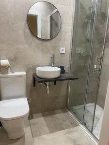 a bathroom with a toilet and a sink and a mirror at Barcelona PR Guesthouse in El Prat de Llobregat