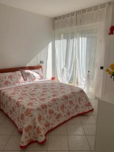 1 dormitorio con cama con colcha de flores en tittihome, en San Remo