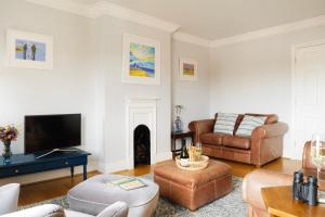 ein Wohnzimmer mit Sofa und Fernseher in der Unterkunft High View, Southwold High Street (2 bed, 2 bath, allocated parking, balcony) in Southwold