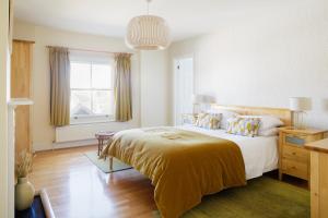 ein Schlafzimmer mit großem Bett und Fenster in der Unterkunft High View, Southwold High Street (2 bed, 2 bath, allocated parking, balcony) in Southwold