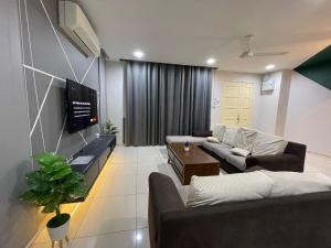 a living room with couches and a flat screen tv at Langkawi kuah Modern Spacious 4R Homestay in Ulu Melaka