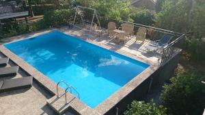 an overhead view of a large swimming pool with chairs around it at Casa Piedra Libre in Manzanares el Real