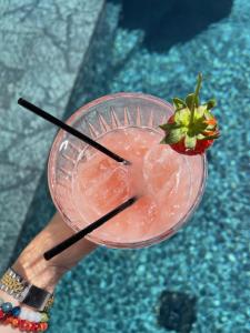 a person holding a drink with a strawberry on it at Rhea Alaçatı Boutique Hotel in Alacati