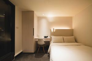 台北市にあるスウィーオ ホテルのベッドとデスクが備わるホテルルームです。