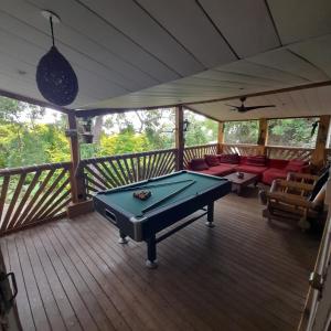 a screened in porch with a pool table on a deck at Freedomhome974 in Le Tampon