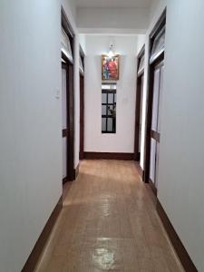 un pasillo con paredes blancas y suelo de madera en Brothers Homestay, en Darjeeling