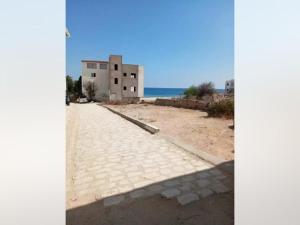 a building on a beach with the ocean in the background at Appartement Cerine 1 , nur 100 Meter bis Tantana Strand in Port El Kantaoui