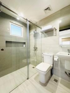 a bathroom with a toilet and a glass shower at Furnished Rentals at Mangrove Residences Mactan in Punta Engaño