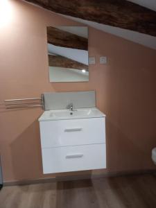 y baño con lavabo blanco y espejo. en Gîte à 25 minutes du Puy du Fou, en Montournais