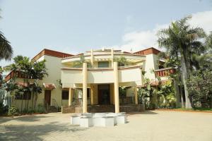 a large house with palm trees in front of it at Shanthi Nivaas in Chennai